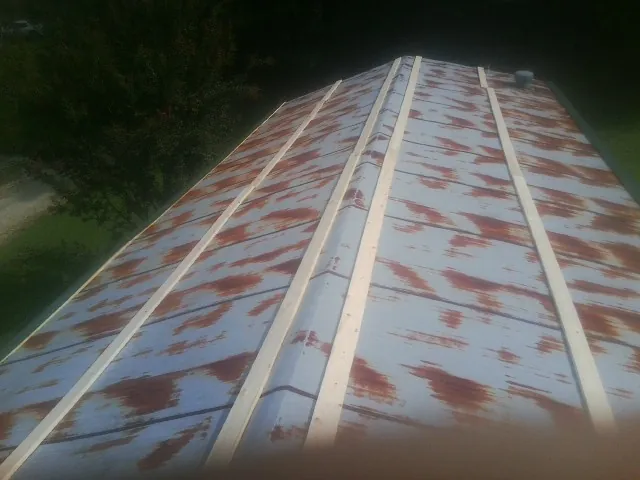 Rusted metal roof panels with new wood purlins before replacement — Storm Damage Roof Repair in Brock by Roofing Brothers