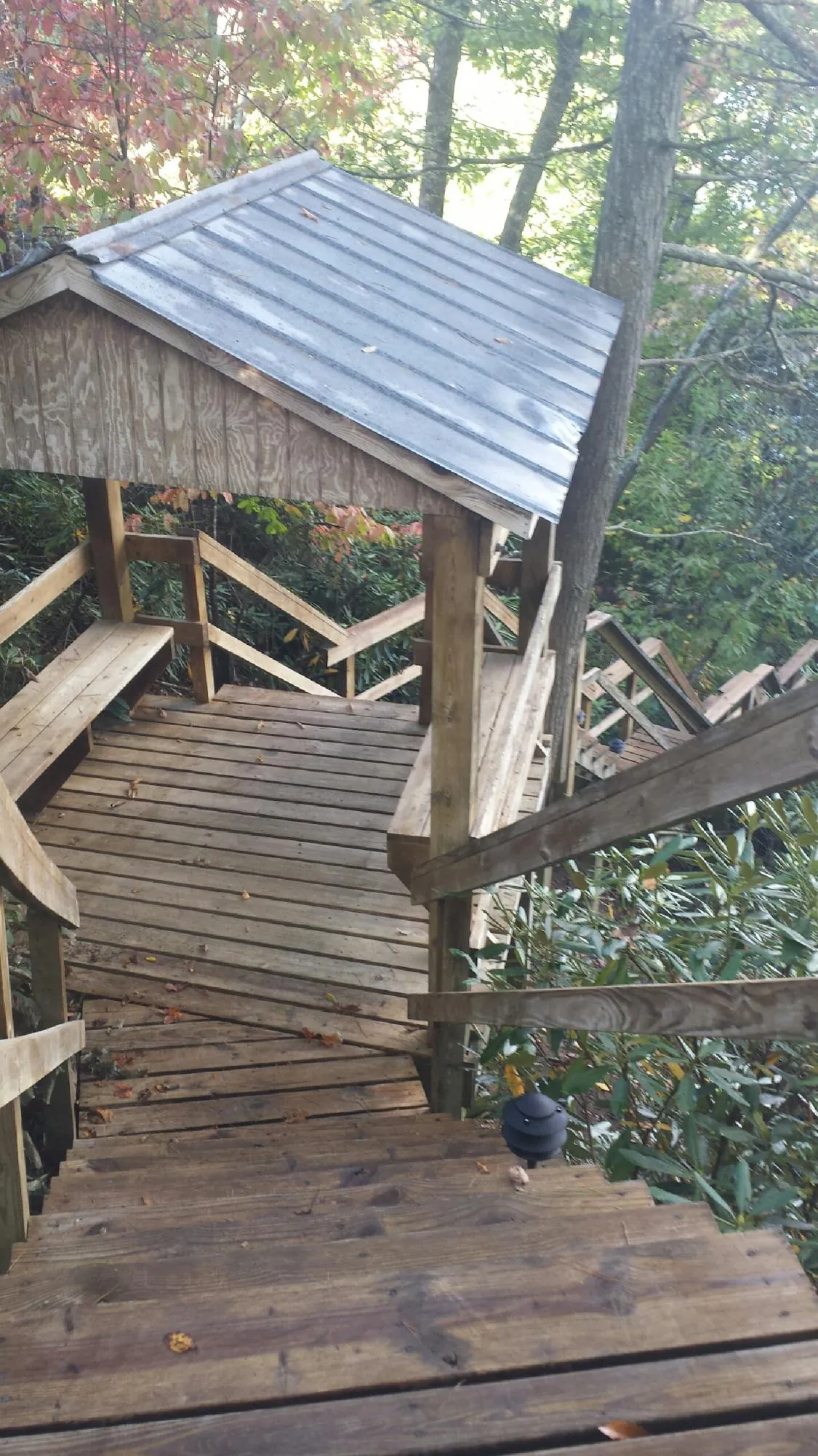 Metal roofed shelter over wooden steps on a wooded walkway — Skylight Repair & Installation work by our crew in Brock