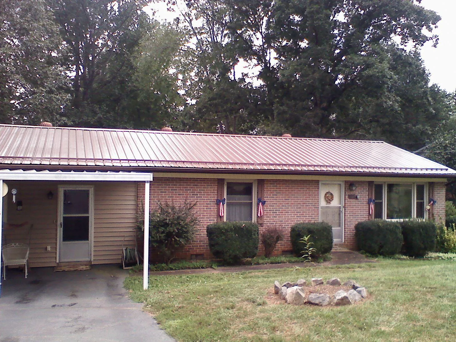 Bronze metal roof and carport on a brick ranch home — Roof Repair work by our crew in Brock