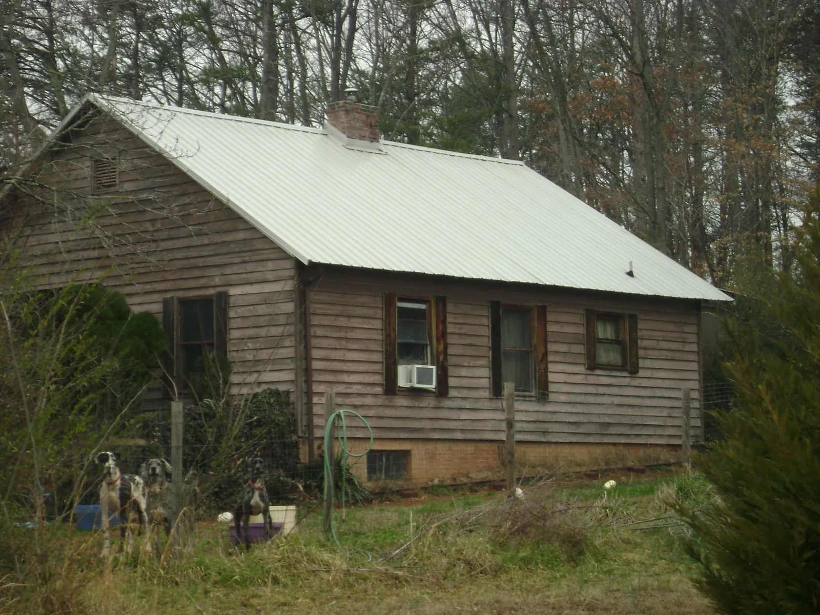 White metal roof on an old wood sided farmhouse, from a Metal Roof Installation job in Brock